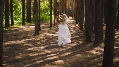 bride with loose hair in sneakers runs through pine forest