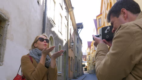 man with retro camera shooting flirty blonde