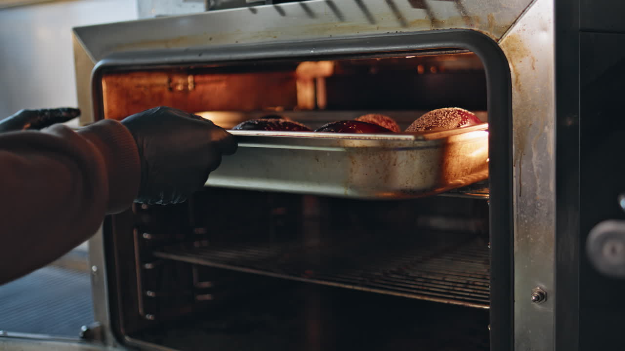 Chef placing eggplants oven for cooking closeup. Unknown professional working