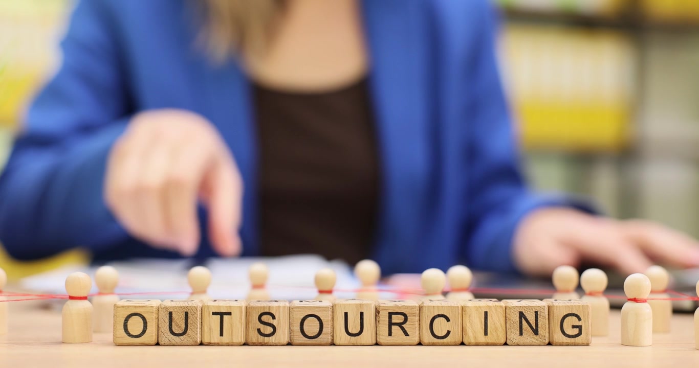 Word outsourcing from cubes against woman working on laptop