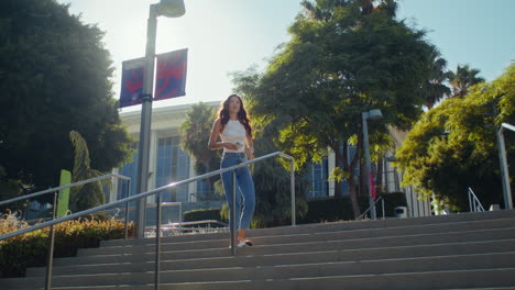 young woman making selfie on stairs. asian girl walking upstairs taking picture