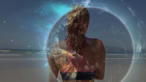 animation of globe over caucasian woman stretching at beach