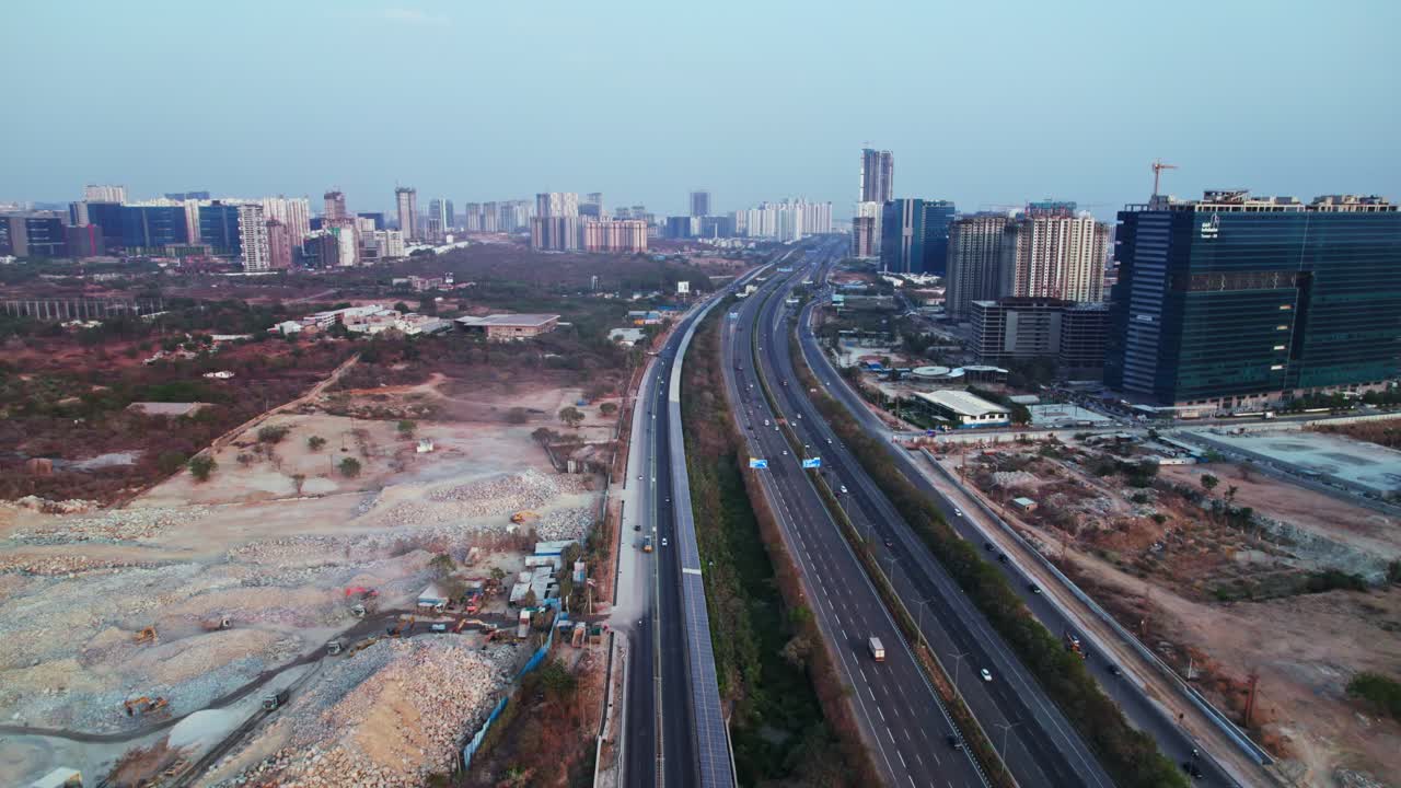 concrete mining with under construction buildings and outer ring road at financial district, Nanakramguda, hyderabad, india. day time, push in, drone shot, 4k.