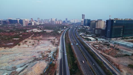 concrete mining with under construction buildings and outer ring road at financial district, nanakramguda, hyderabad, india. day time, push in, drone shot, 4k.