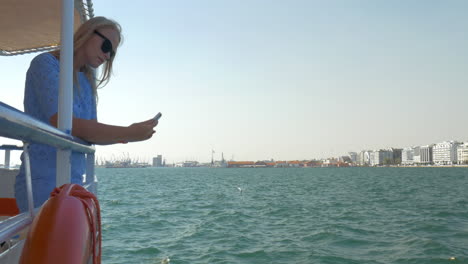 Girl-travels-by-boat-in-sea-of-city-Thessaloniki-Greece-and-photographed-seascape