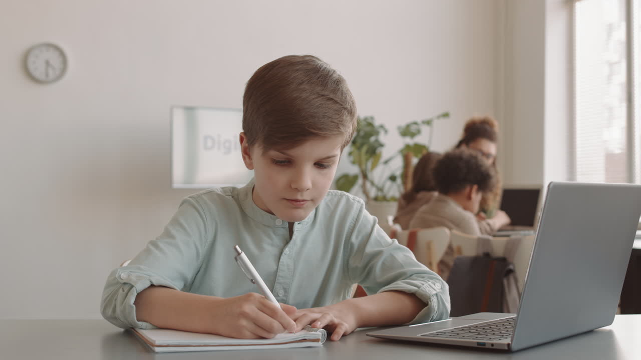 Caucasian Boy Using Laptop in Classroom