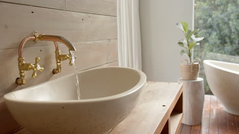 Close-up-of-washbasin-with-running-water-in-bathroom,-slow-motion