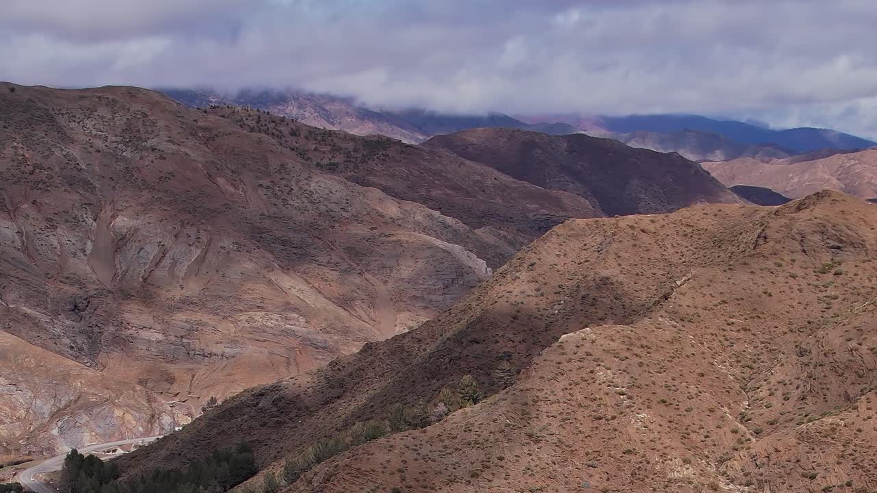 Vista aerea di montagne in Marocco con chiazze verdi e terreno roccioso.