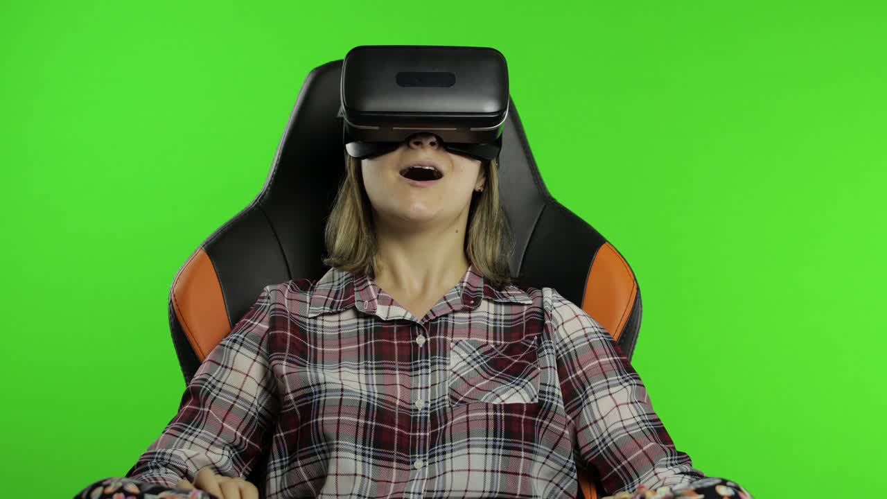 Young woman using VR headset helmet to play game. Watching virtual reality 3d 360 video. Chroma key