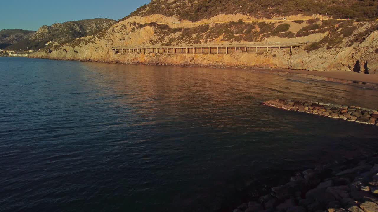 amanecer en el puerto de ginesta con muelle de piedra y aguas tranquilas en barcelona