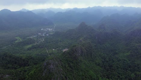zoom in drone shot of rocky coast and emerald water in cat ba island on a bright day