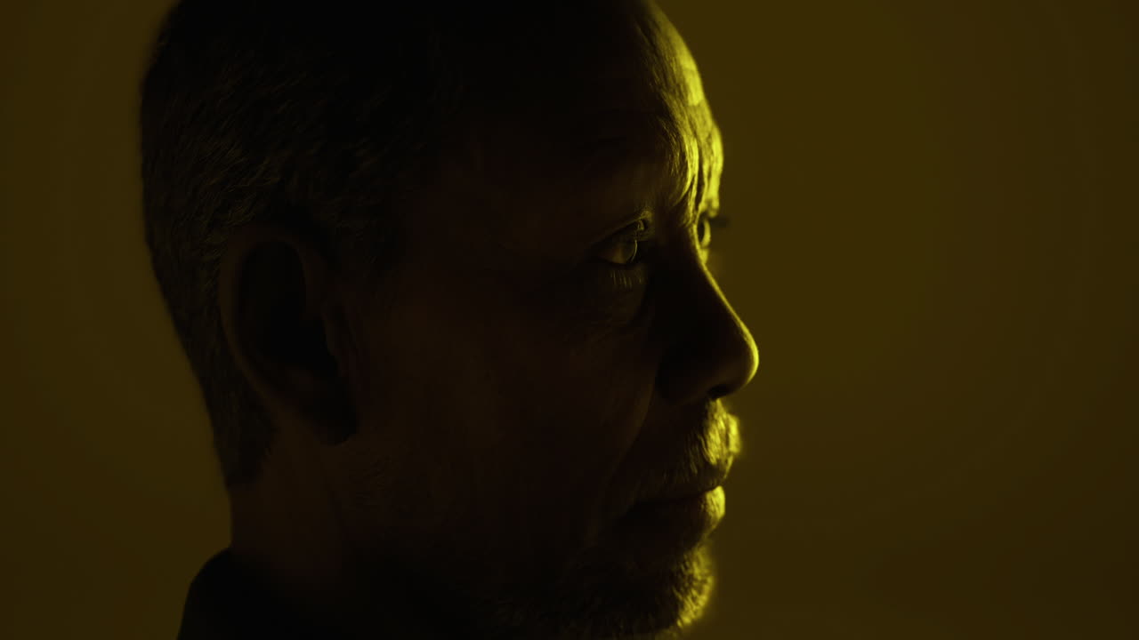 Close up of a man with deep expression in warm dim light setting