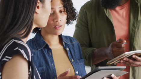 Diverse male and female friends in discussion, working together at home, in slow motion