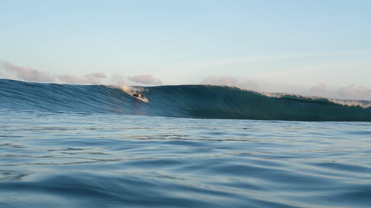 Surfer riding cresting wave in Mui Ne showcasing thrilling coastal surf action in Binh Thuan Province Vietnam. The powerful wave crashes as surfer glides across ocean surface