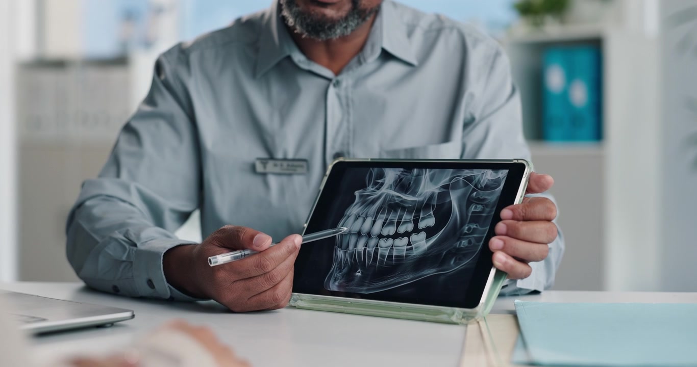 Dentist Explaining Dental X-ray to Patient on Tablet