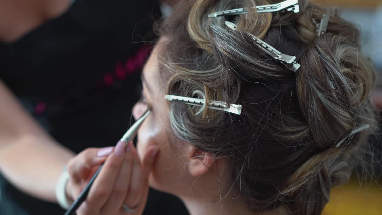 Bride with hair clips being make up