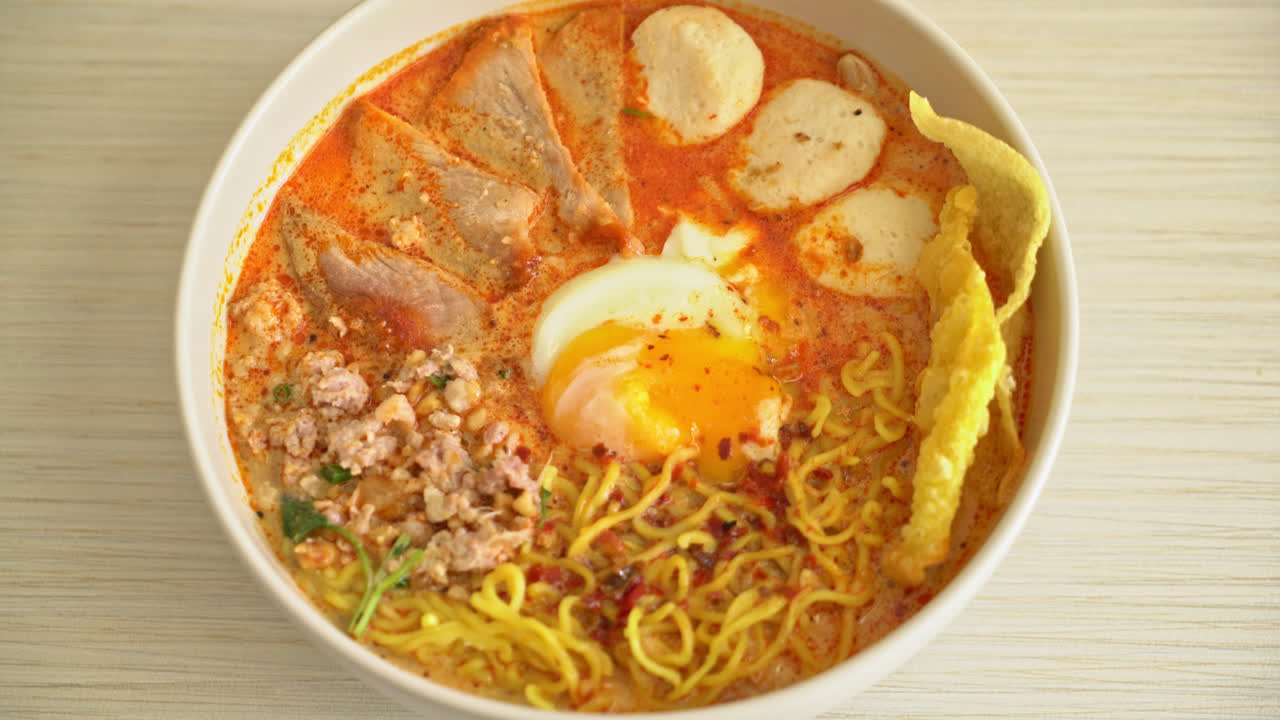 fideos de huevo con carne de cerdo y albóndigas en sopa picante o fideos tom yum al estilo asiático