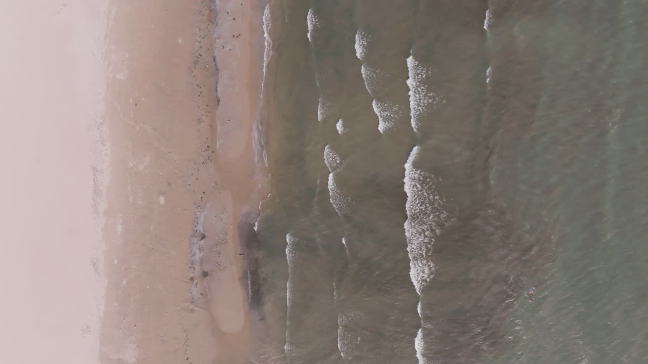 Aerial view of Nickel Beach, waves gently hitting the sandy shore
