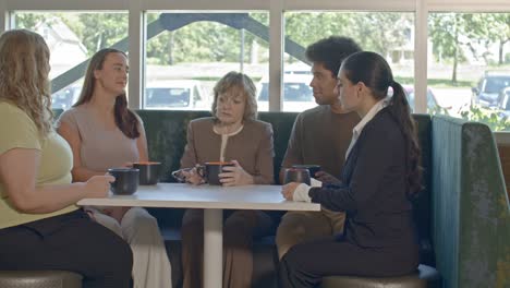 office meeting close up with one senior citizen woman and four younger workers with video dolly right to left