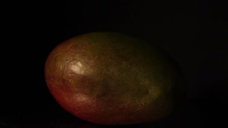 la luz se mueve hacia la izquierda sobre la fruta del mango en la oscuridad