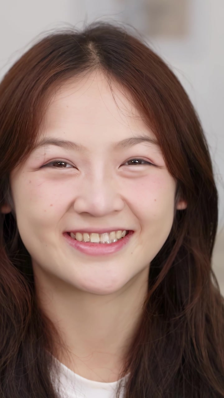 환하게 웃으며 OK 사인을 만들고 있는 쾌활한 젊은 아시아 여성의 클로즈업.