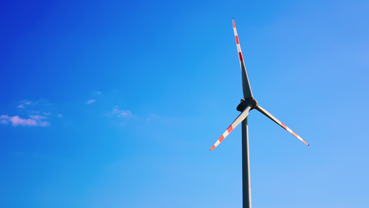 Wind turbine against clear blue sky. A wind turbine stands tall against a bright blue sky, showcasing renewable energy innovation in a natural setting