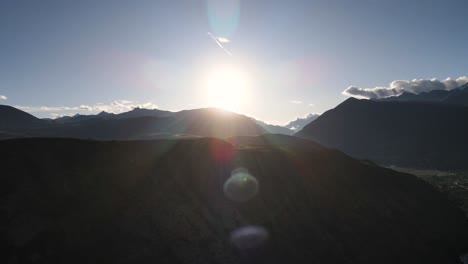 aerial of the sun above the mountains of urubamba, sacred valley, cusco, peru. drone slow pan