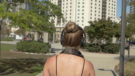 Attractive woman skating in park while listening to music in headphones (Cinematic Slow Motion)