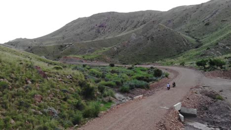 aerial shot of bike riders riding on a rough road near khuzdar in balochistan, pakistan