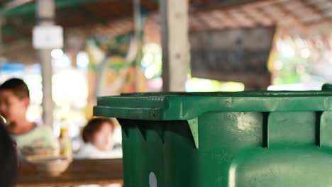 throwing away rubbish at a market bin