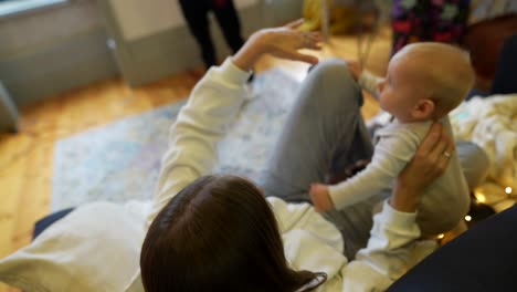 mother and baby playing on couch