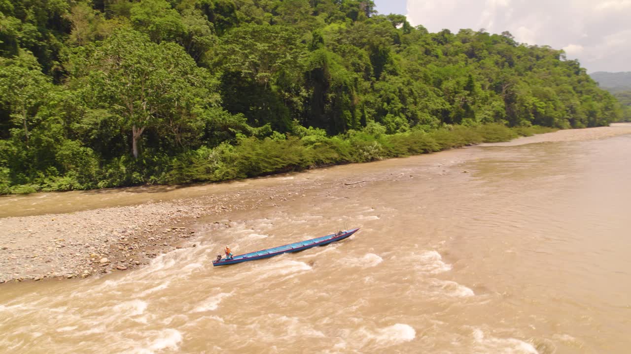 una larga canoa navegada por los lugareños en las aguas fangosas del río oxapampa, rodeada de densa selva