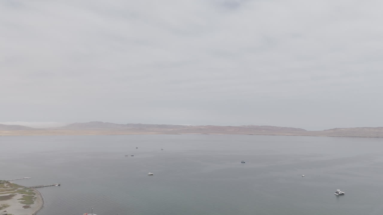 Drone shot above the city Paracas in Peru during a cloudy day with a view on the sandy dunes LOG