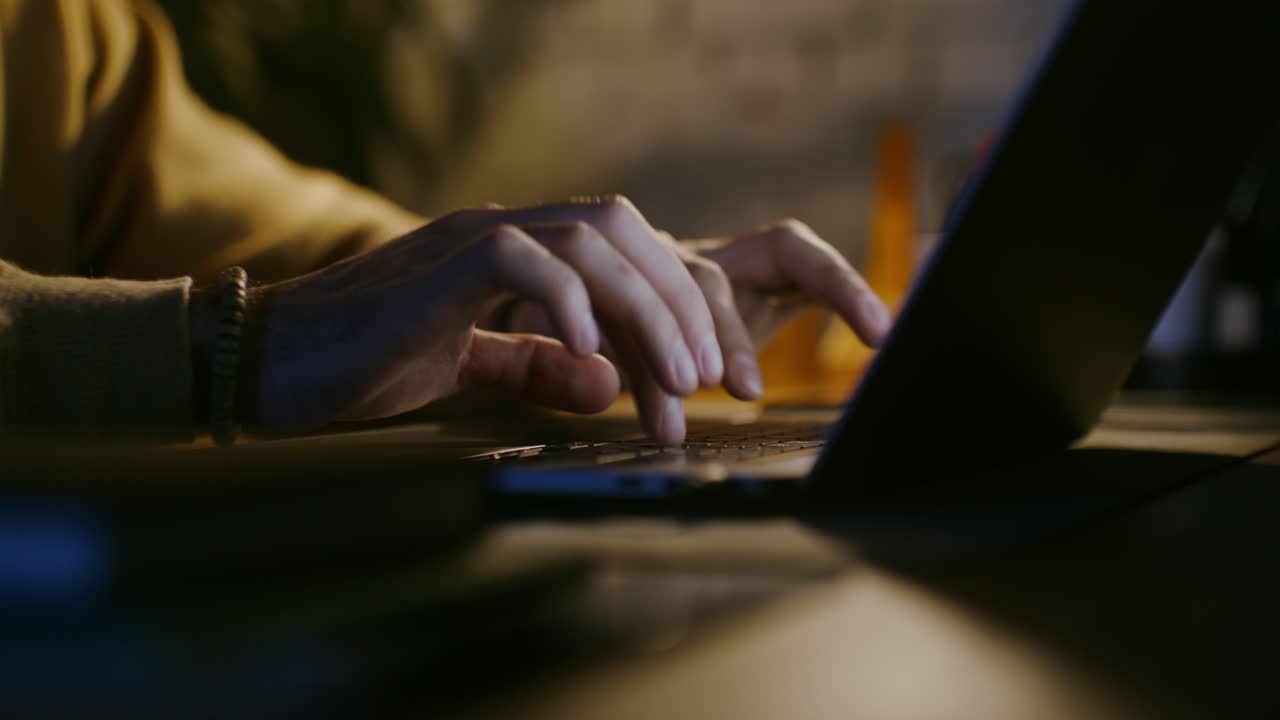 Persoon die's nachts op de laptop typt