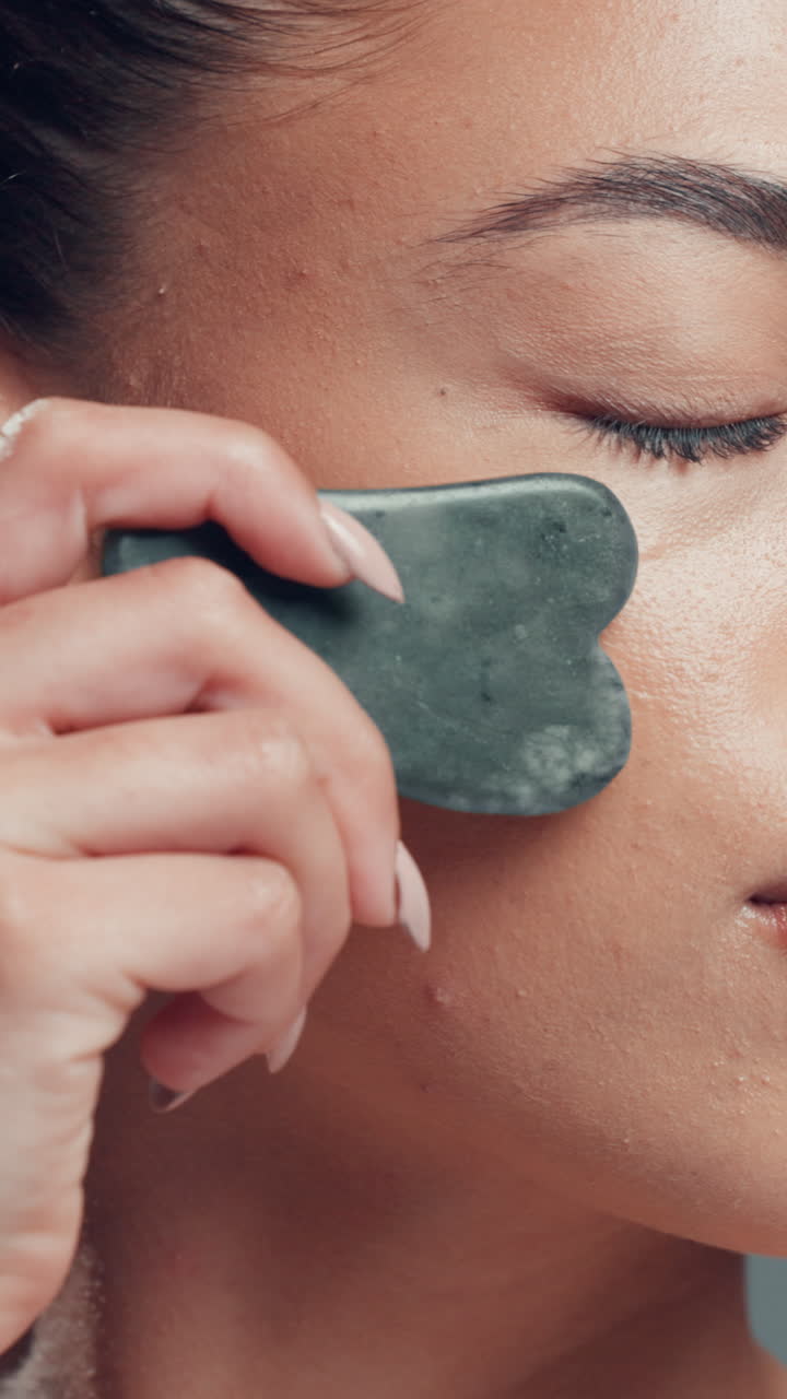 Close-Up of Woman Using Gua Sha Tool for Facial Massage