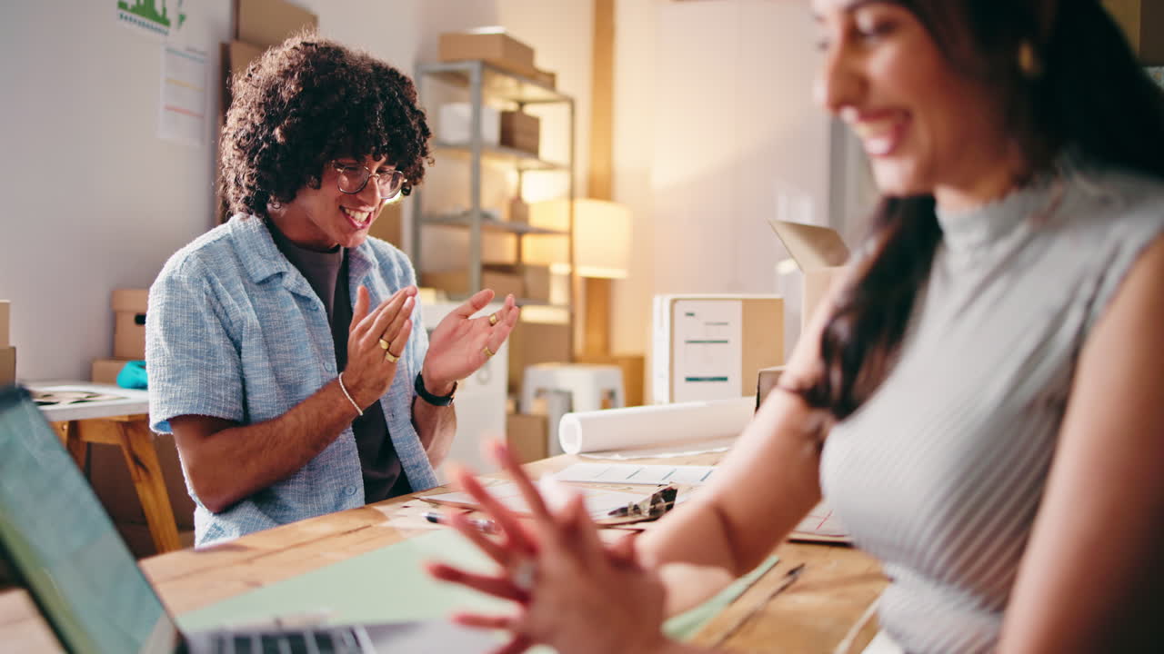 Happy Young Business Partners High-Fiving and Celebrating Success in Office