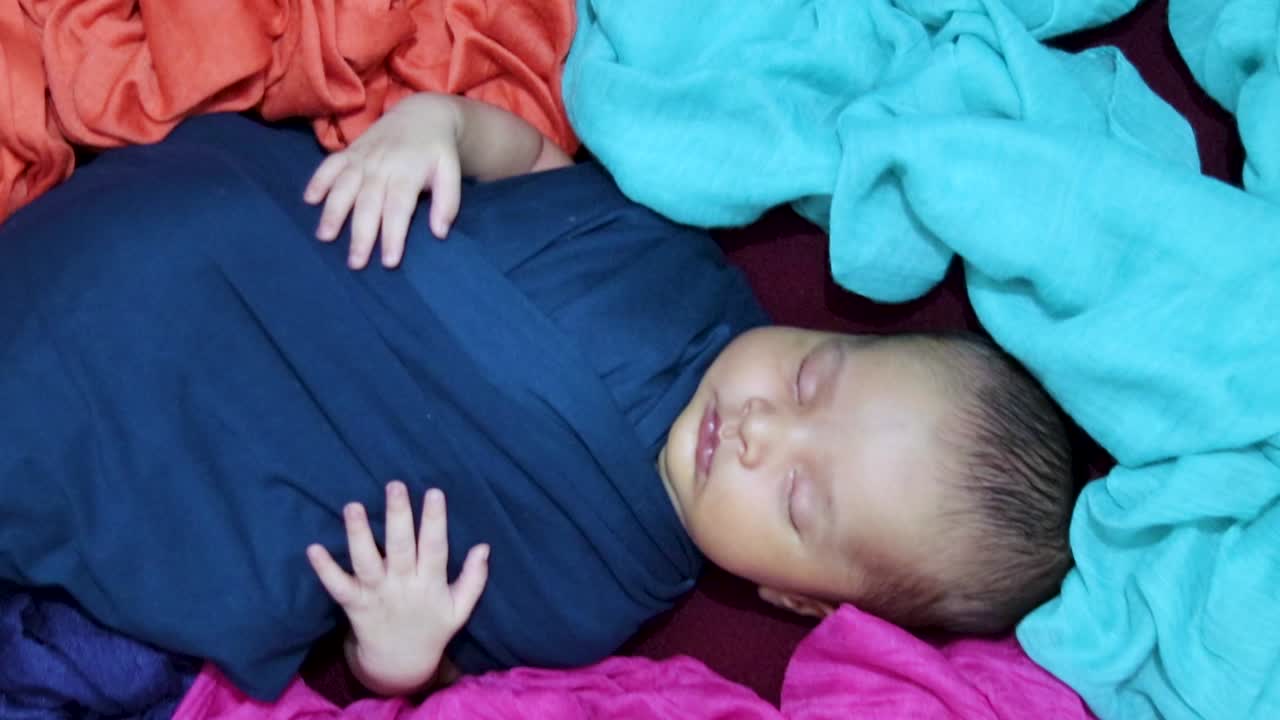 un bambino neonato carino che dorme in un involucro per bambini in uno stile unico da un angolo superiore