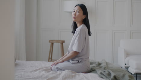 woman sitting on bed in pajamas