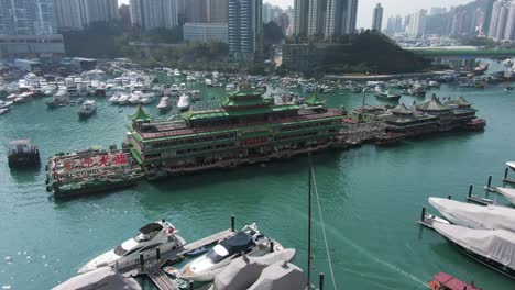 Jumbo floating restaurant in Hong Kong Aberdeen Harbour typhoon shelter, Aerial view with skyscrapers in the background and boats.