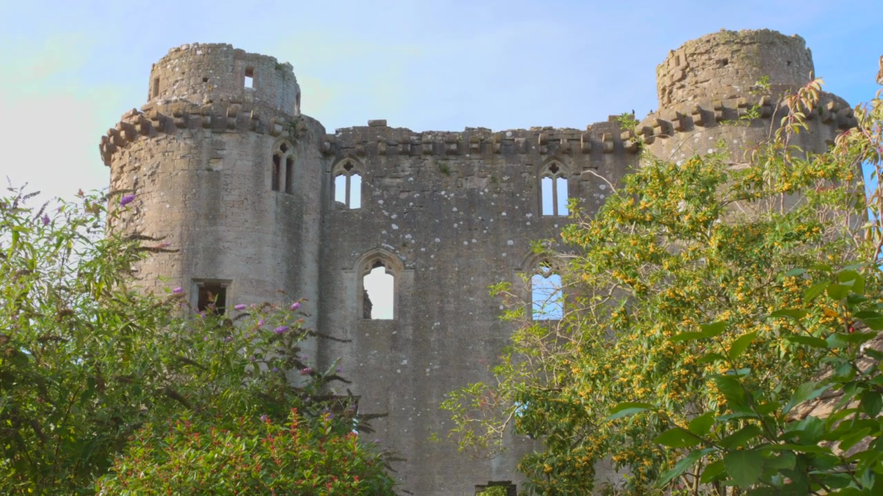 Castello di Nunney a Nunney, Inghilterra, che mostra mura storiche in pietra e un ambiente verdeggiante, vista aerea
