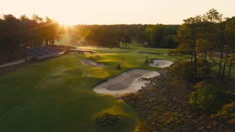 drone shot of golf course maintenance workers or grounds crew prepping a green during sunrise