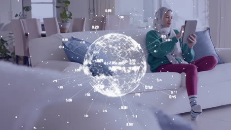 Animation-of-globe-with-network-of-connections-over-biracial-woman-in-hijab-using-tablet