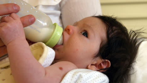 young baby drinking from a milk bottle