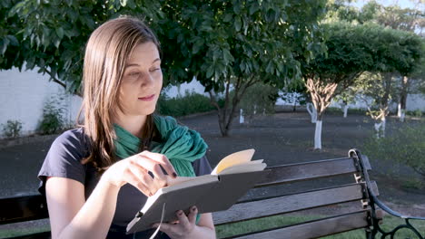 woman and book sitting alone on the square bench