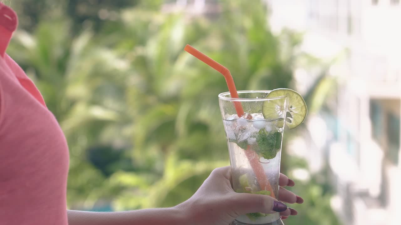 푸른 손바닥이 분홍색 셔츠를 입은 여자의 뒤에 흔들리고 있습니다.