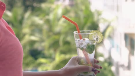 blurry-green-palms-swing-behind-woman-in-pink-shirt