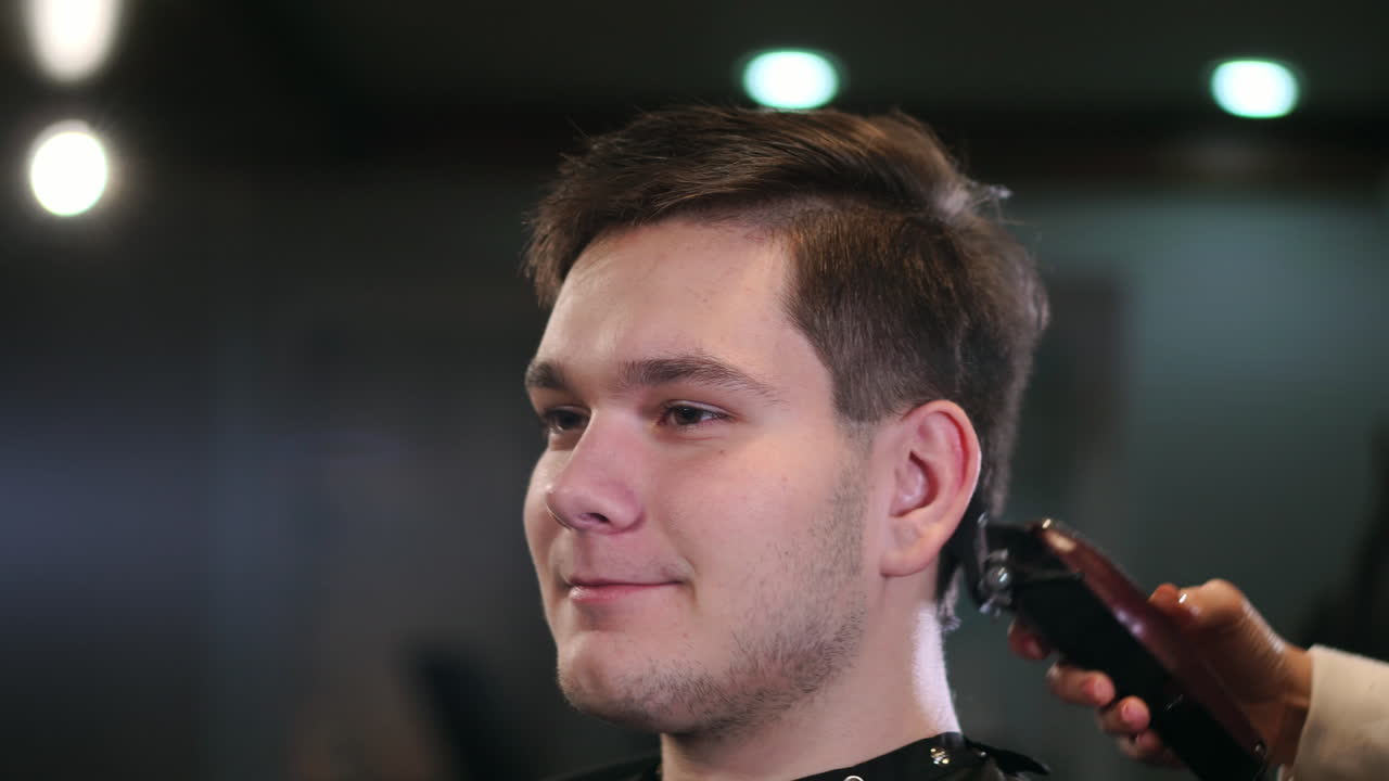 corte de pelo masculino con maquinilla de afeitar eléctrica. primer plano del peinado de cortador de cabello. peluquero profesional cortando el cabello con cortadora de cabello. peluquería masculina con afeitadora eléctrica