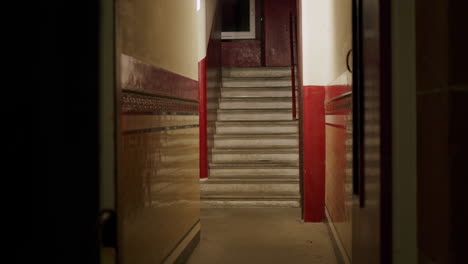 Stairway-of-apartment-block-at-night,-handheld