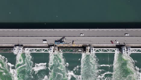 Statische-Luftaufnahme-Von-Oben-Auf-Das-Sturmflutwehr-Der-Ostufer-Schelde-Mit-Ein-Paar-Vorbeifahrenden-Autos-Und-Vielen-Darüber-Fliegenden-Möwen