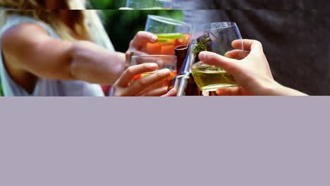 group of happy friends toasting glasses of drinks at outdoors barbecue party